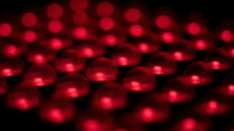 Macro van een raster rode lichtpunten buiten focus met zachte gloeiende halo's